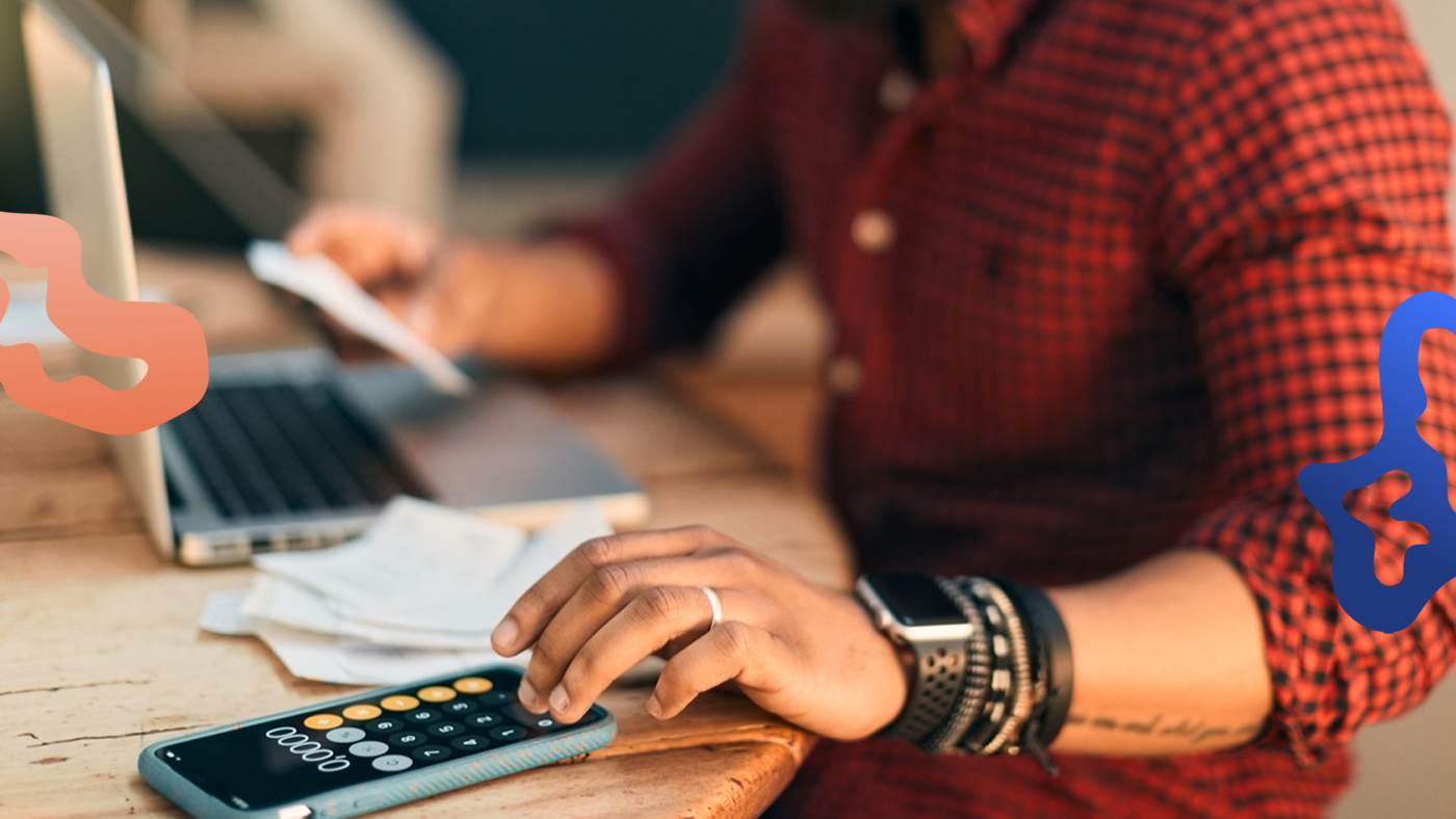 Arbetsgivare förbereder lönesättning med hjälp av laptop och mobiltelefon.