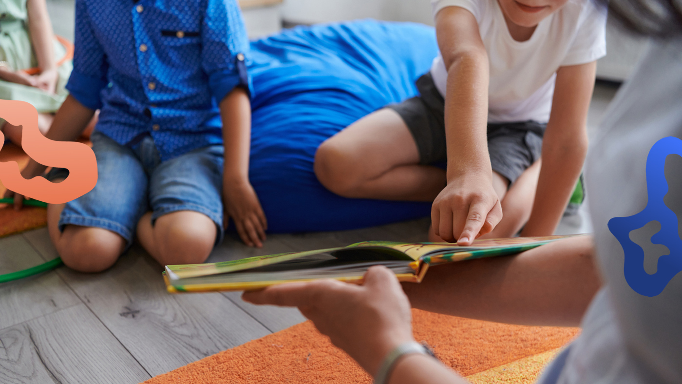 Förskollärare med behörighet läser en bok för barnen på förskolan.