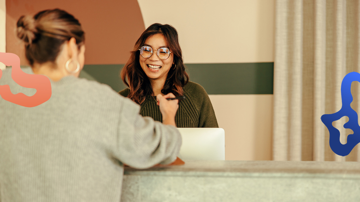 Receptionist med jobb i Stockholm hjälper en gäst.