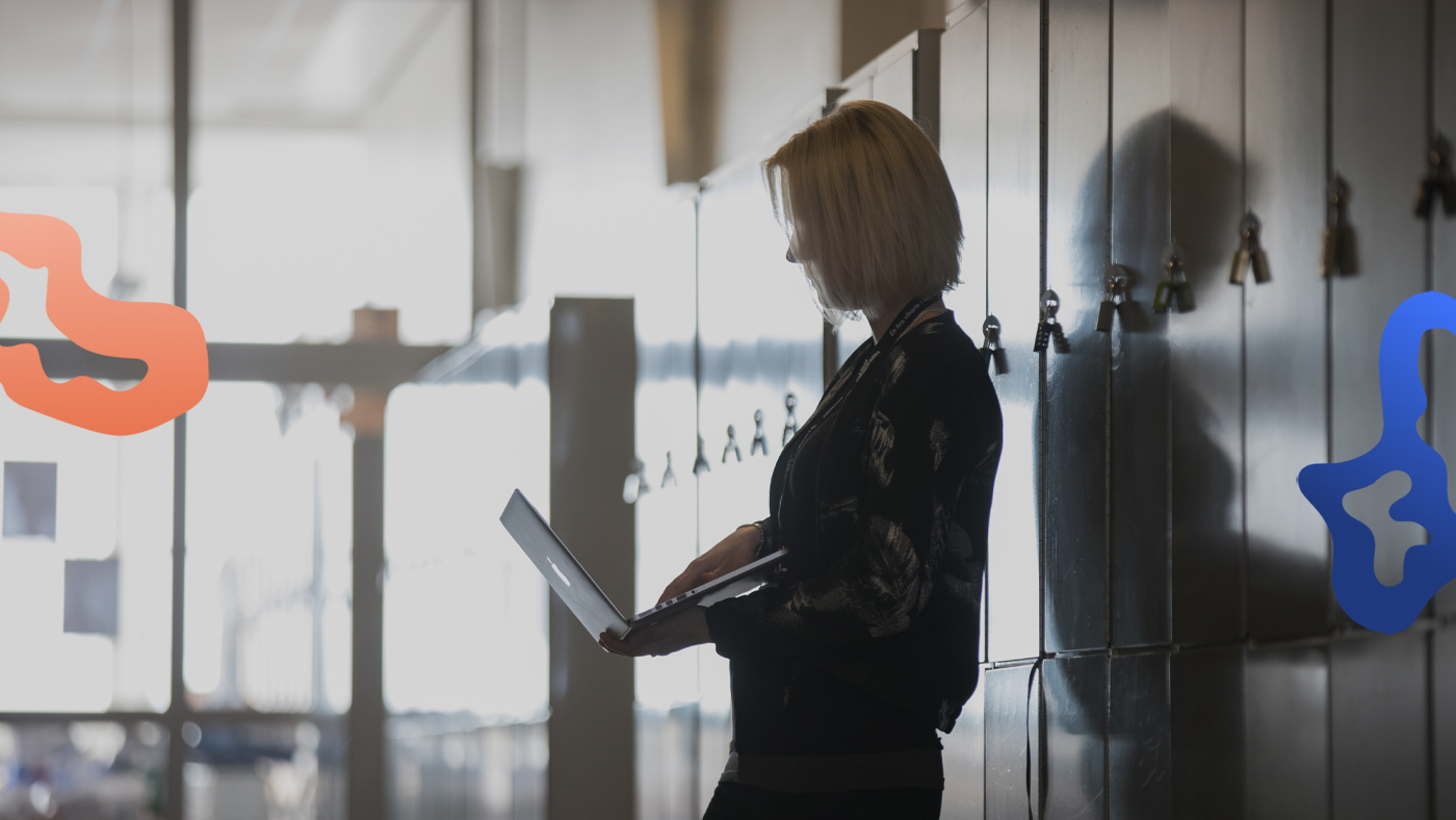 Vikarie i skolan står med sin laptop och planerar dagen.
